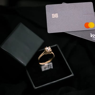 Ring in box with gift cards beside it